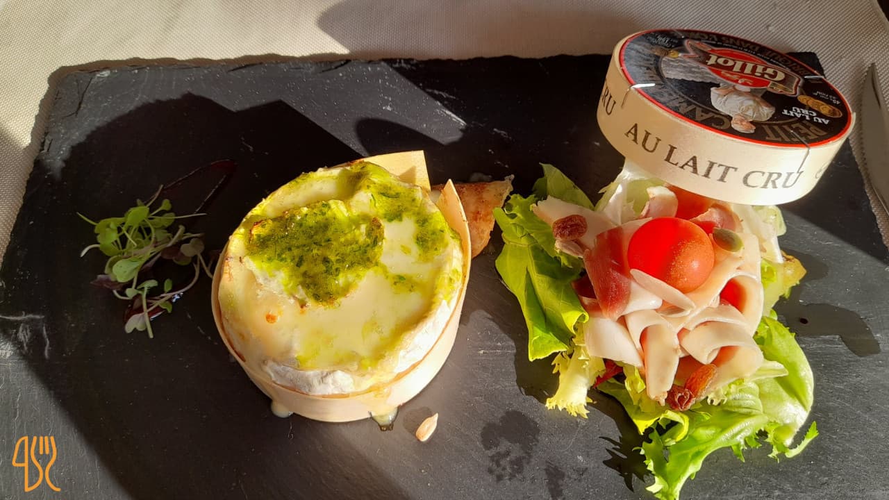 Camembert rôti au lait cru avec pesto, jambon et salade fraîche